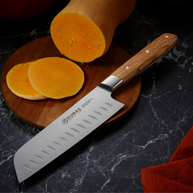 Couteau Santoku 18 cm 32 Dumas Signature avec lame alvéolée en acier 4116N et manche en chêne vert, présenté dans un coffret premium.